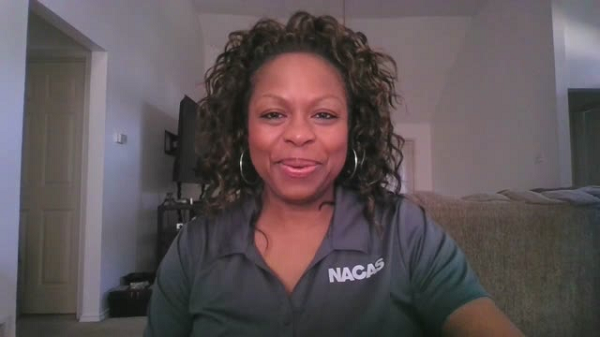 Lynette Smith, Director of Regions at NACAS, is wearing a gray NACAS branded polo. She is smiling.