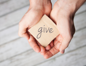 Hands holding card that says Give